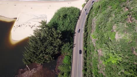 Imágenes-De-Drones-A-Lo-Largo-De-La-Carretera-En-La-Costa-Norte-De-La-Isla-De-Oahu-Hawaii-Con-Una-Playa-De-Arena-Blanca-Que-Separa-El-Agua-Marrón-Del-Océano-Cristalino