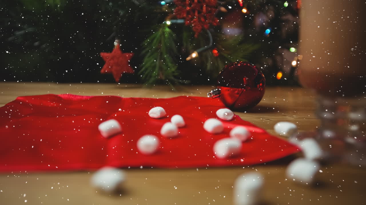 Animazione di neve che cade su decorazioni natalizie e marshmallow