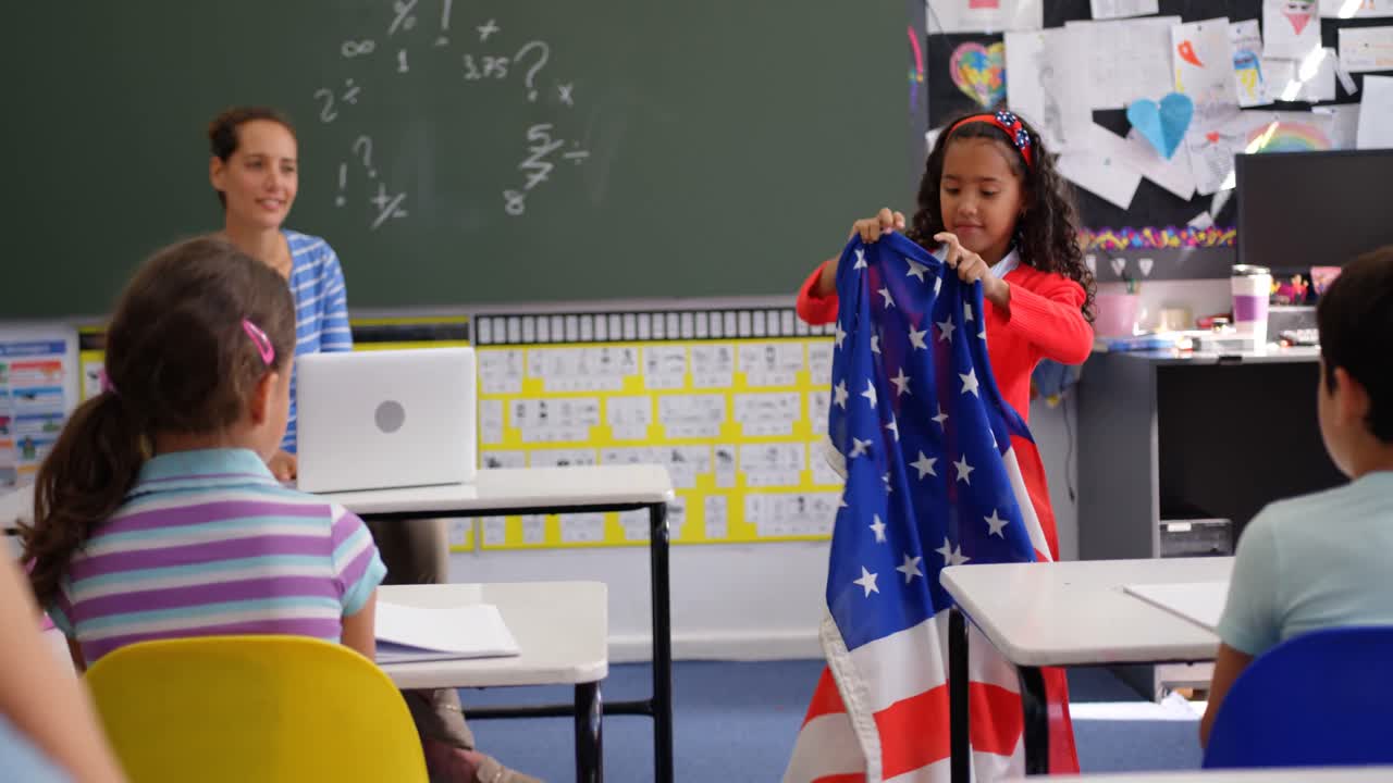 vista frontal de una colegiala afroamericana explicando sobre la bandera estadounidense en el aula 4k