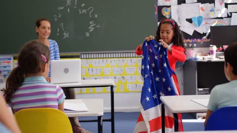 Vista-Frontal-De-Una-Colegiala-Afroamericana-Explicando-Sobre-La-Bandera-Estadounidense-En-El-Aula-4k