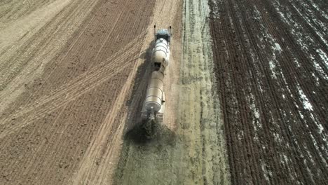 a tanker spreads liquid manure on a wisconsin farm field recently harvested of corn silage