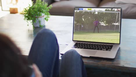 Video-Einer-Person,-Die-Auf-Der-Couch-Sitzt-Und-Sich-Ein-Fußballspiel-Auf-Dem-Laptop-Ansieht