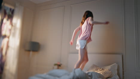 excited woman jumping bed in morning. happy beautiful girl dance home in pajamas