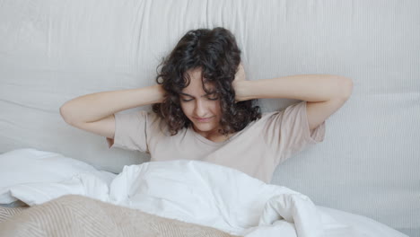 Woman Covering Ears in Bed