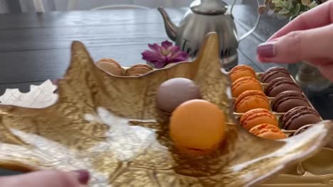 fiesta de té con temática otoñal con coloridos macarons franceses perfectamente colocados en un plato de hojas festivas