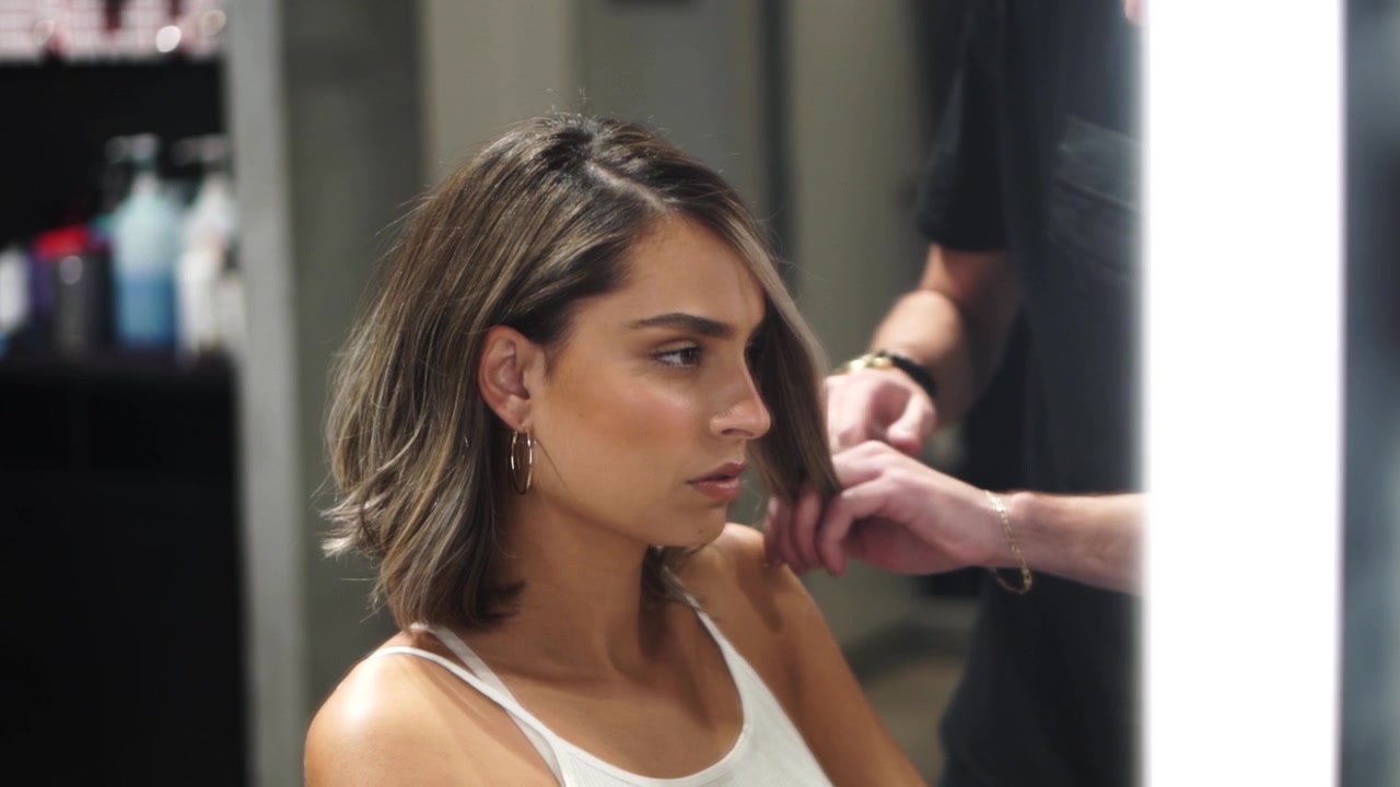 Barbeiro trabalhando no cabelo de uma menina.