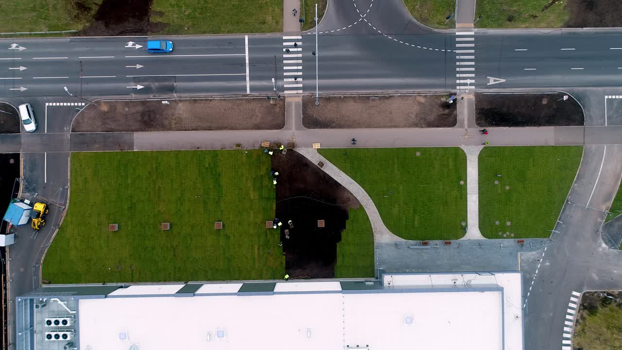 Top-down aerial view of earthworks and landscaping near building and road infrastructure