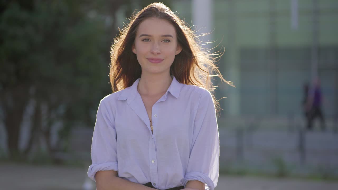 disparo medio de una mujer bonita afuera mirando a la cámara, sonriendo