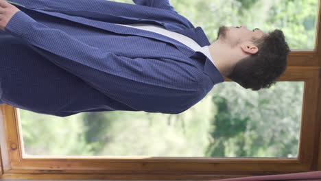 vertical video of the man opens the closed curtains in his house.