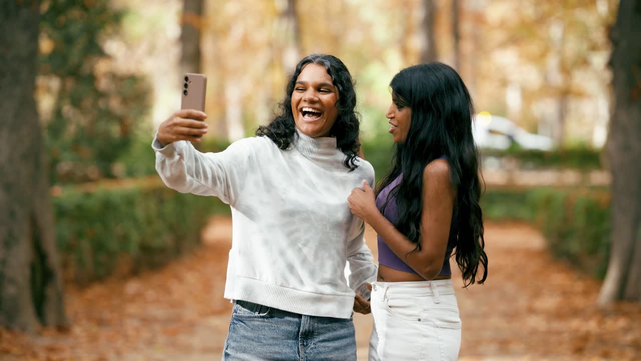 Due giovani donne che si fanno un selfie in un parco