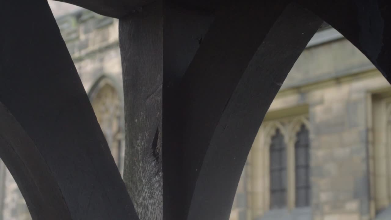 View of old stone built English Church through lych gate archway