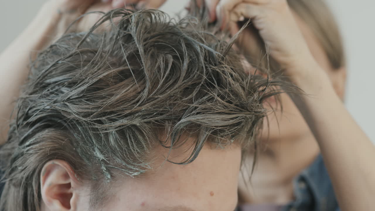 Hairstylist Backcombing Hair of Actor