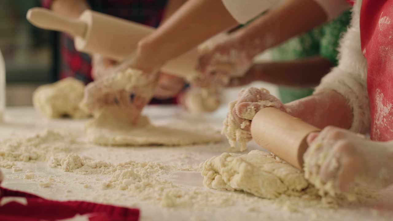 Handheld view of family rolling the dough for Christmas cookies