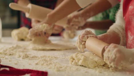 handheld view of family rolling the dough for christmas cookies