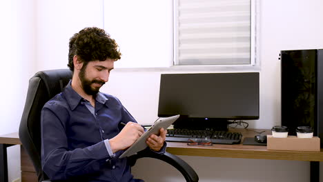 Latin-man-smiling-and-typing-on-tablet