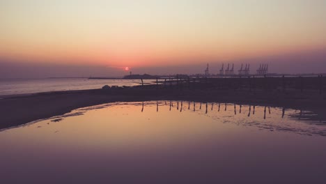 Puesta-De-Sol-Naranja-En-El-Horizonte-Con-El-Puerto-De-Karachi-Visto-Desde-La-Playa-Con-Vistas-Al-Mar