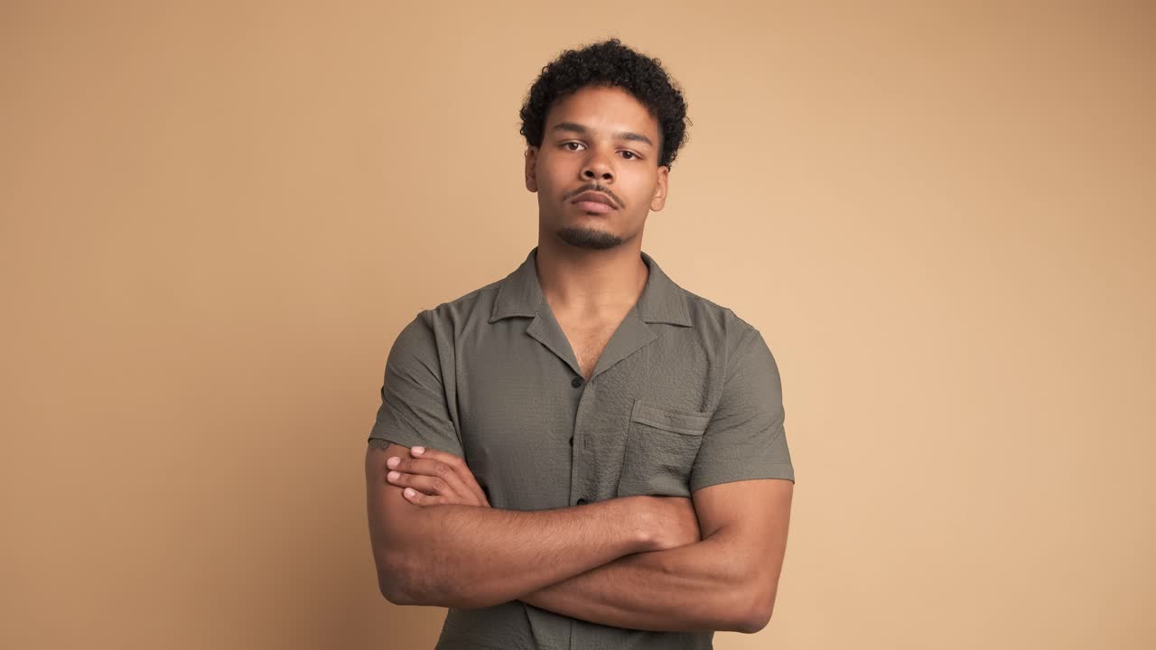 Confident man looking at camera in beige studio