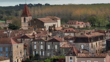 magnífica puesta de sol sobre la ciudad bastida de monpazier, vista aérea desde un avión no tripulado, los rayos del sol iluminan la pequeña ciudad todavía dormida, dordogne, francia