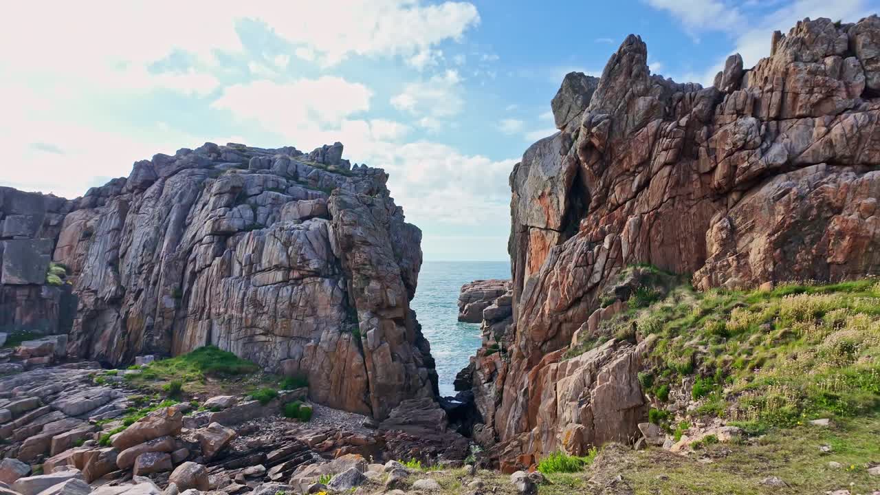 Le Gouffre de Plougrescant, rugged granite cliffs and sea, Brittany, France. Aerial forward at low altitude