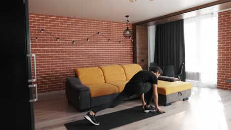 hombre atlético haciendo una embestida hacia adelante, estirando las piernas antes del entrenamiento