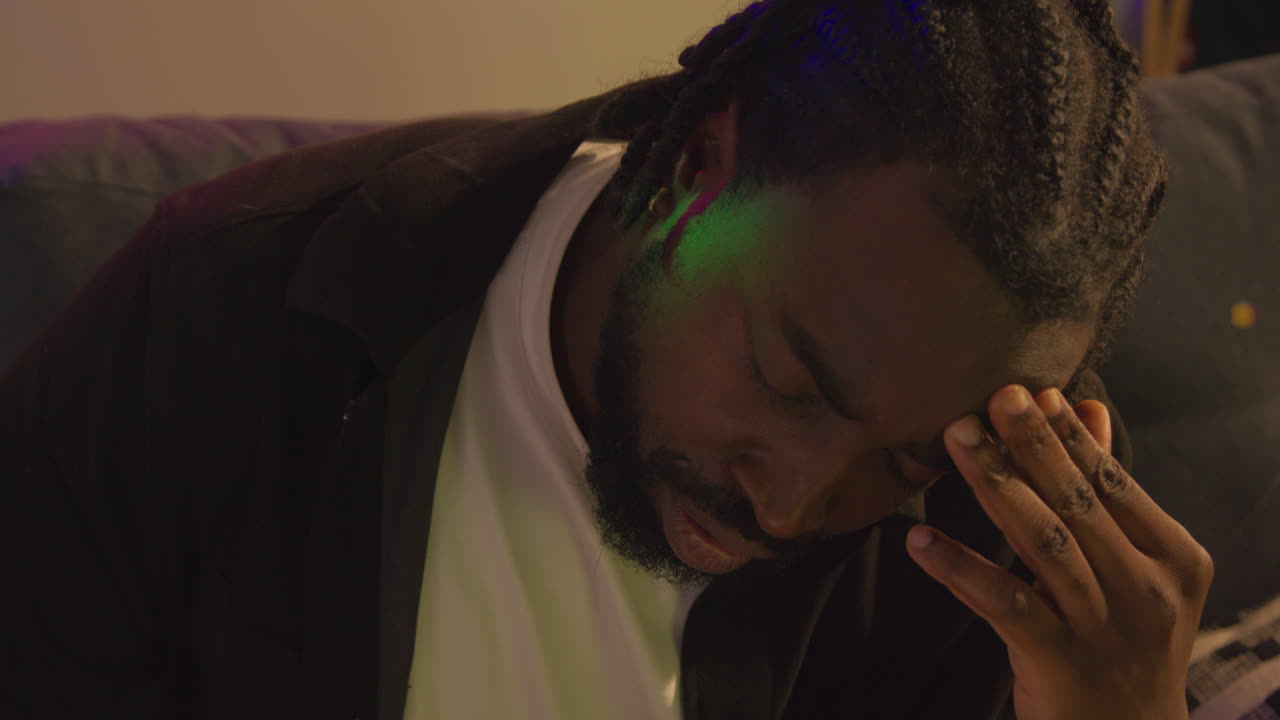 primer plano de un hombre despertando en el sofá después de beber alcohol en una fiesta de casa sufriendo de resaca 1