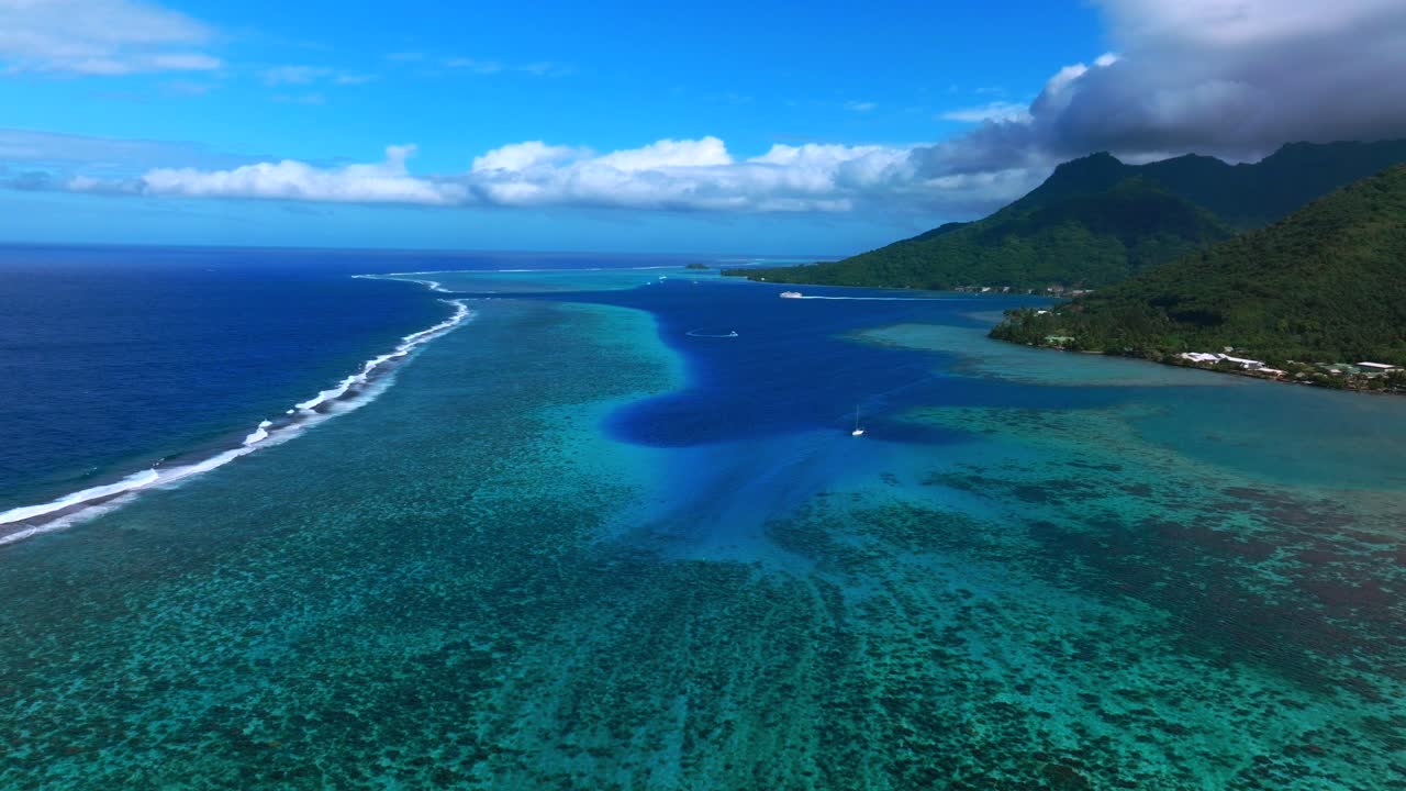 Opunohu-bugten på Moorea, Fransk Polynesien, luftfoto med drone med koralrevsmønstre, lyse turkise laguner, krydstogtsmotorbåd og en bred havpassagekanal, der strækker sig langs den tropiske økystlinje