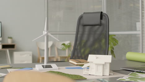 wind turbine miniature and house model on office table 1