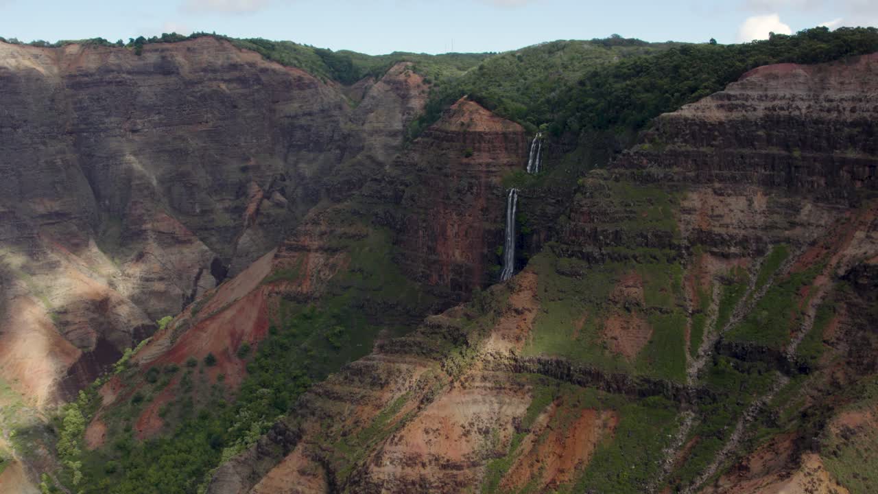 toma aérea cinematográfica sobre la famosa cascada de waipo'o en el parque estatal del cañón de waimea
