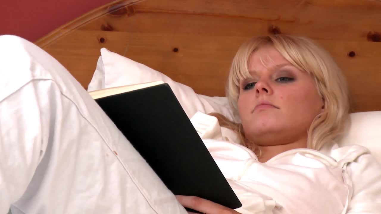 침대에 누워 책을 읽고 있는 사랑스러운 여자