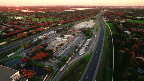 Aerial-drone's-forward-view-over-town-with-a-high-speed-road-next-to-it