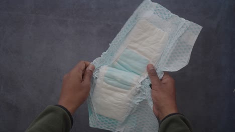 person holding an unfolded baby diaper