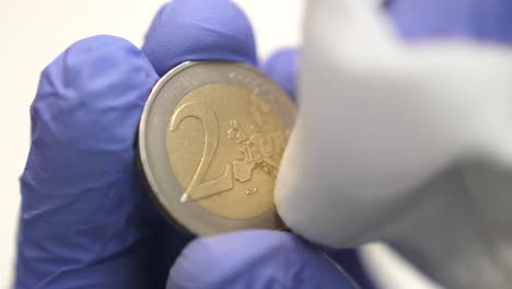 isolated close shot of front two euro coin wiped, coronavirus