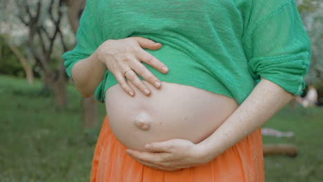 pregnant woman embracing belly outdoor