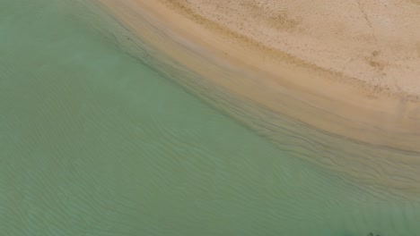 White-sand-beach-Turquoise-pale-ocean-water-drone-aerial-fly-above-coastline-with-small-rocky-islets