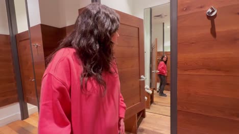 woman trying on clothes in dressing room mirror