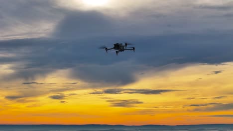 drone silhouette flying against dramatic sunset with gold and blue sky, czechia