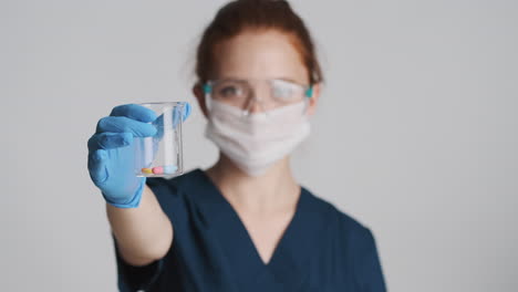 redheaded doctor in front of camera on gray background.