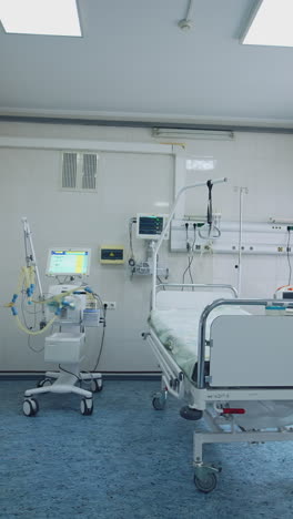 empty resuscitation room in clinic. hospital bed in the intensive care unit with modern medical equipment. clean emergency room. vertical video