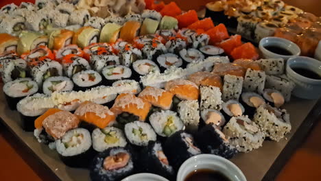 Variety-of-colorful-sushi-on-table,-accompanied-with-soy-sauce