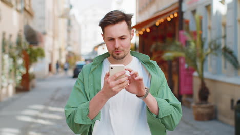 happy man using mobile smartphone celebrating win good message news, lottery casino jackpot victory