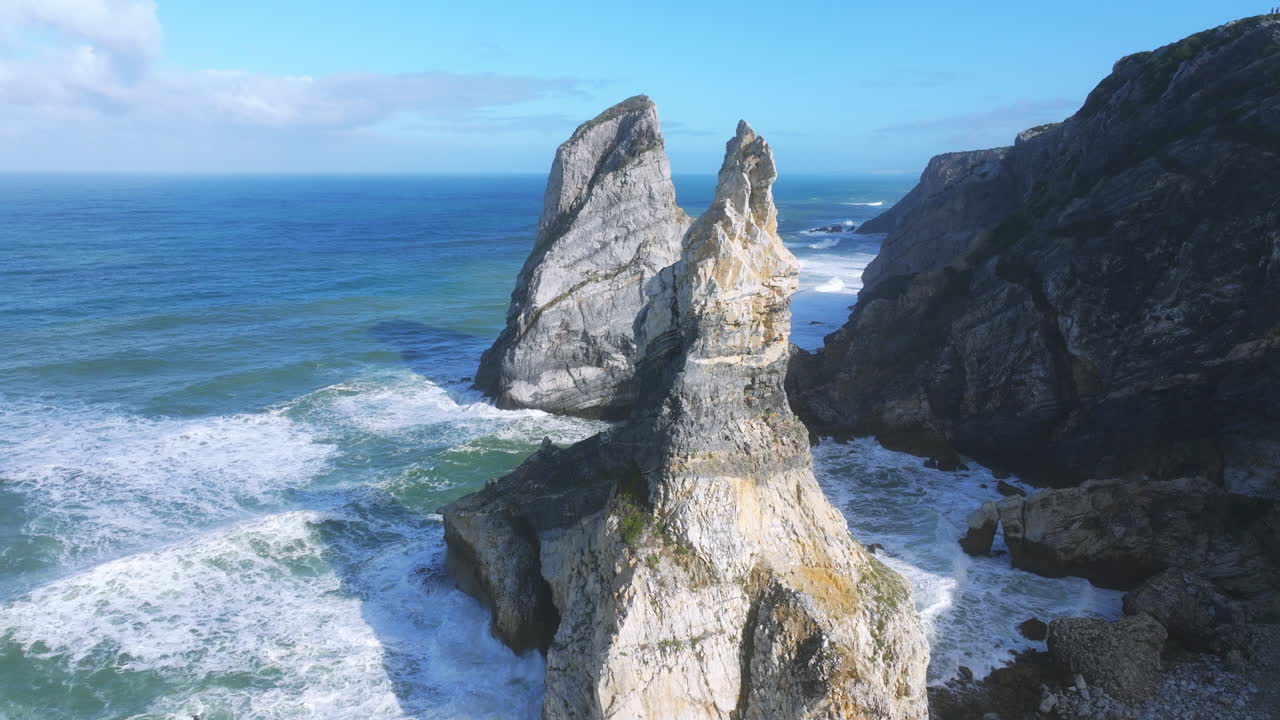 Aerial top-down perspective of Praia da Ursa, showcasing ocean waves. Near Cabo da Roca, sunny morning light.