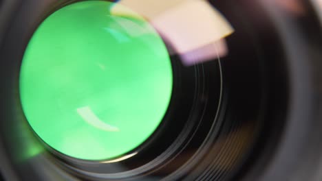 aperture blades opening and closing with green background in a de-clicked lens