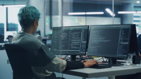 in diverse office: female programmer is working on desktop computer, screen shows coding language user interface. digital entrepreneur creating modern software, e-commerce app design. over shoulder