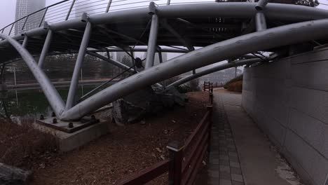 walking towards bridge on misty morning at songdo central park in incheon, south korea. pov shot