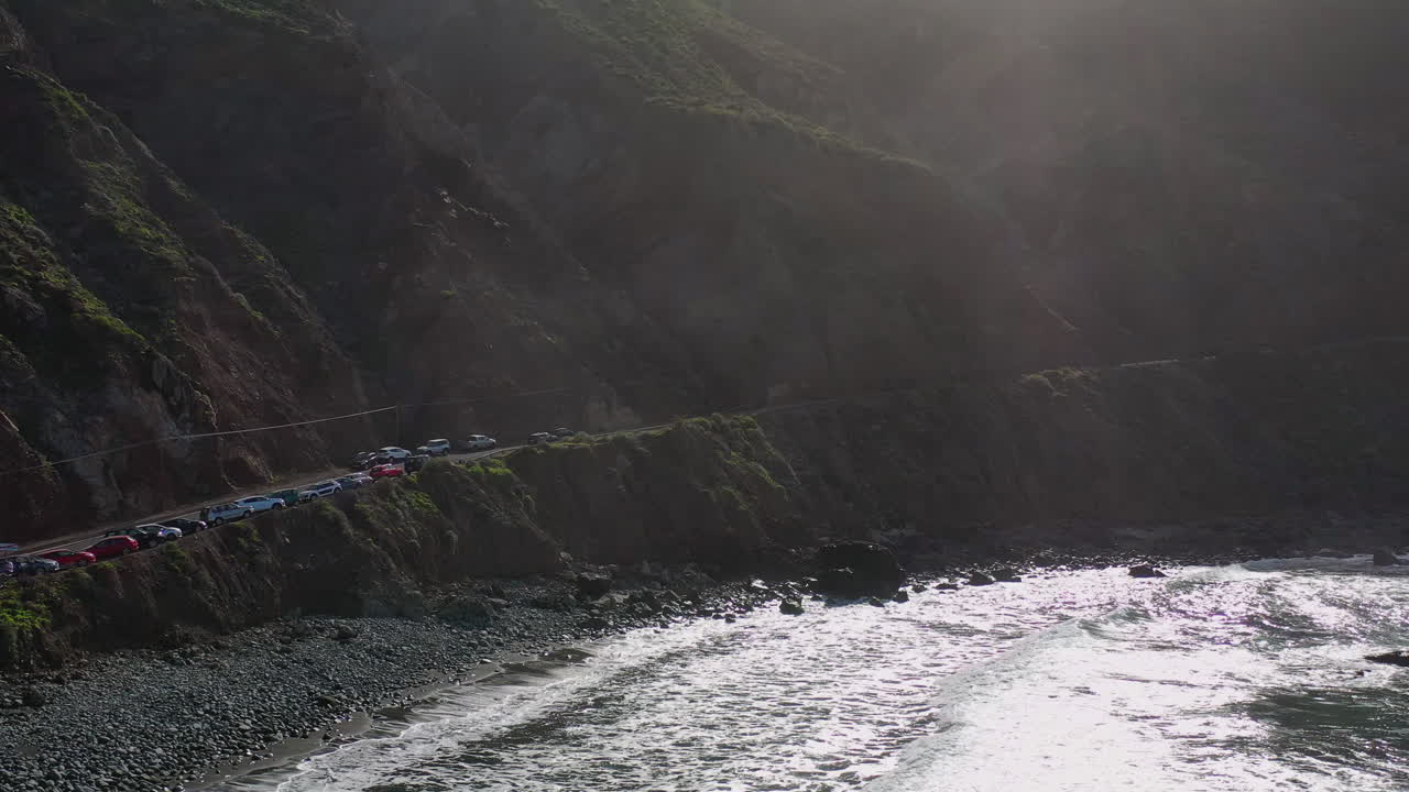 Cars parked on the mountainous ocean coast of Rural de Anaga Park,Tenerife,Spain.