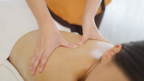 una mujer recibiendo un masaje de espalda en un spa.