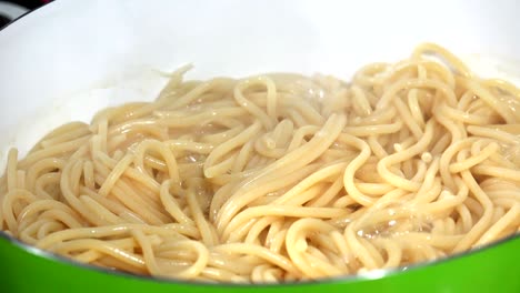 boiling spaghetti in pan on electric stove in the kitchen, loop