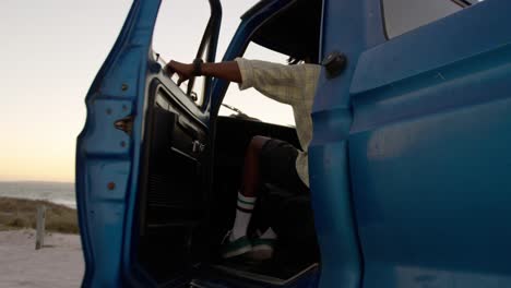 man getting into pickup truck at beach 4k