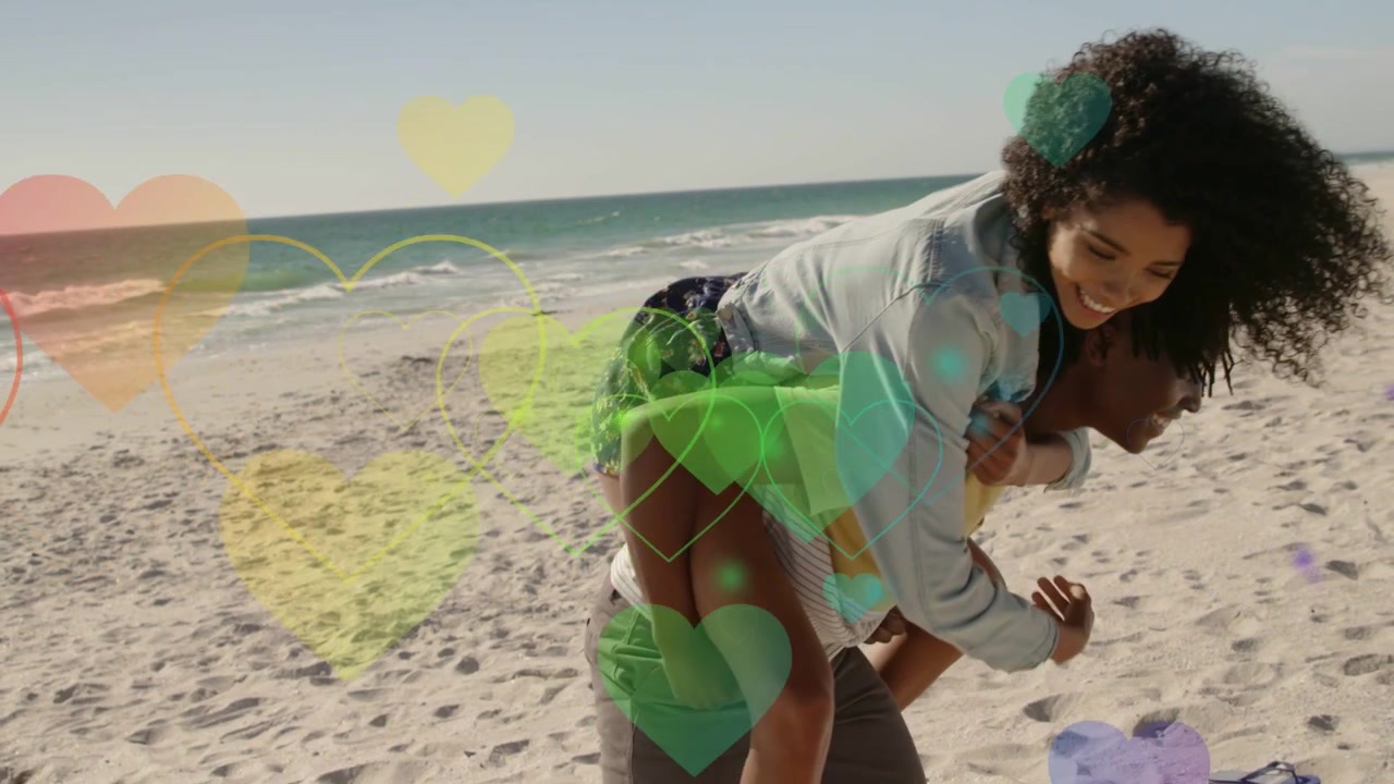 Man carrying woman piggyback after her climb walking beach playfully while hearts floating travel