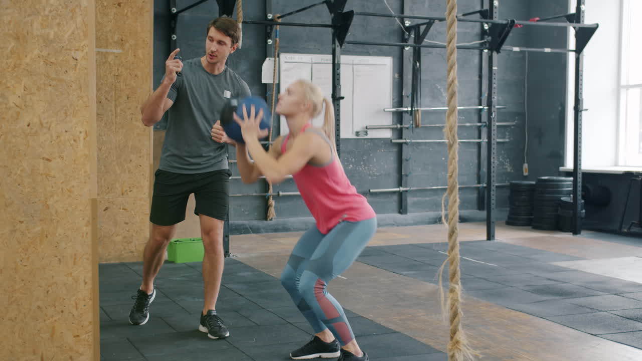 Woman Doing Squats with Medicine Ball, Fitness Training Session